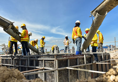 Lead-Construction-Staffing Men pouring concrete in foundation