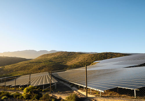 Lead-Industrial-Renewable-Energy Solar panels with mountains in background